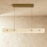 The same slim alabaster bar unlit, four brass bolts set along its face