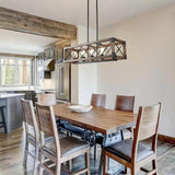 Lit above a wood dining table and dark chairs under an exposed beam