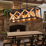 Lit above a long wood table in a room with a stone fireplace and iron legs