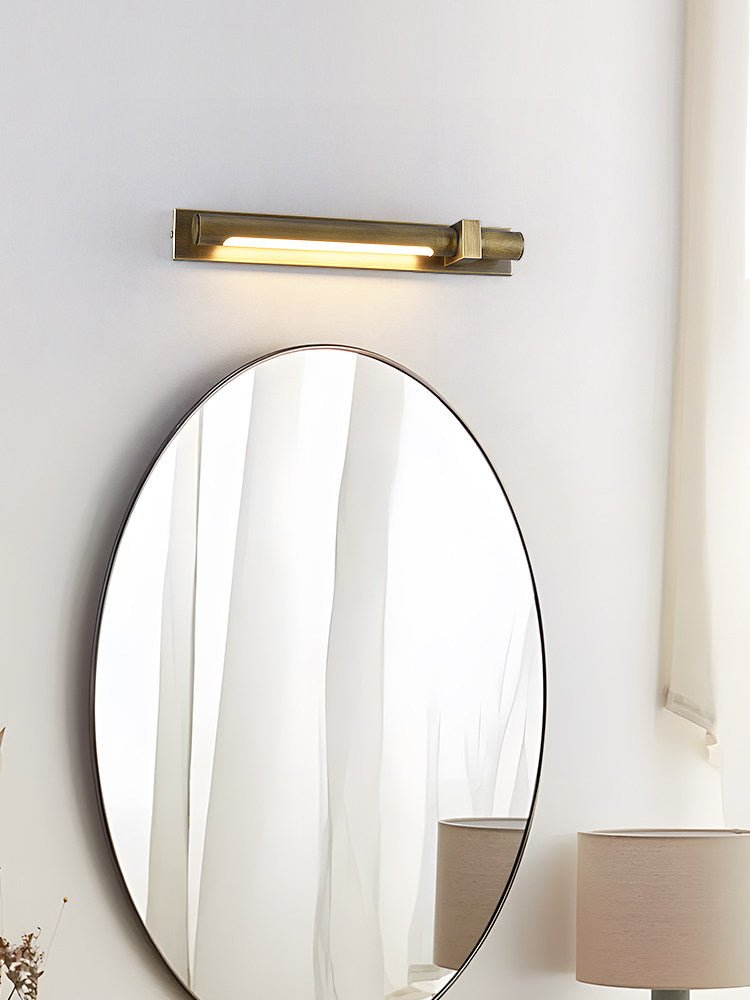 Bronze bar above a tall oval mirror beside a lamp and a pale curtain