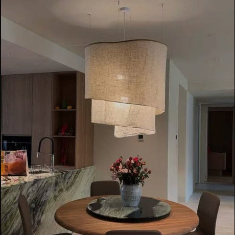 Overlapping fabric shades above a round dining table with flowers