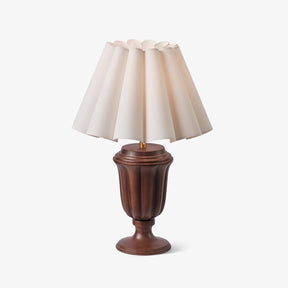 Carved urn base lamp in a walnut tone on a plain white ground