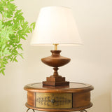 Walnut oversized table lamp lit on a round table in the evening