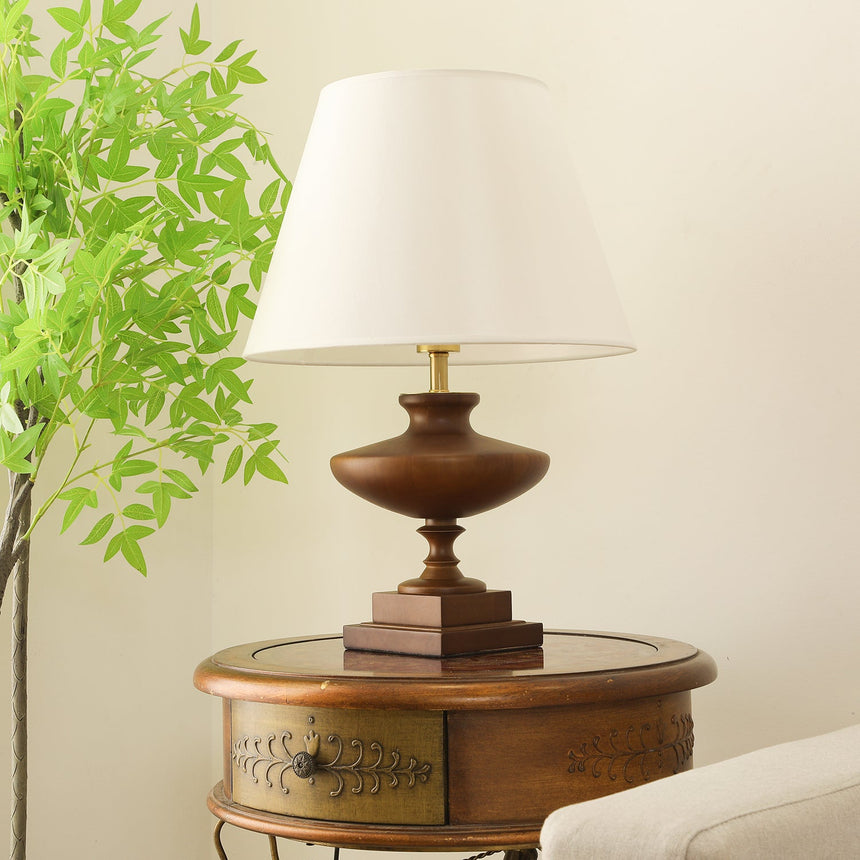 Walnut oversized table lamp seen from the side on a round wooden table