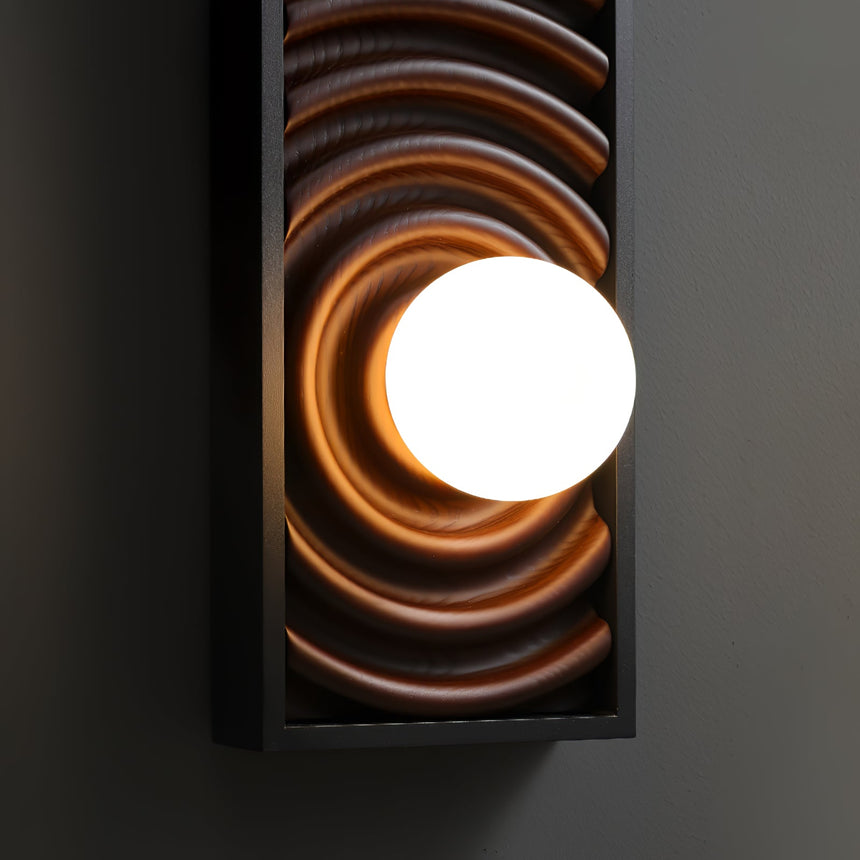 The white glass orb lit bright against the carved rings that circle it