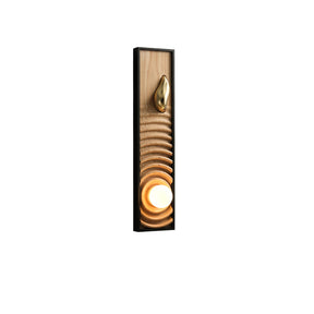Light ash panel carved in ripples inside a black frame, the orb lit at the base