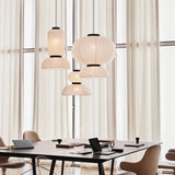 Rice paper lanterns hung above a table in a bright room with curtains