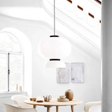 Rice paper lantern hung in a white room with an arched window