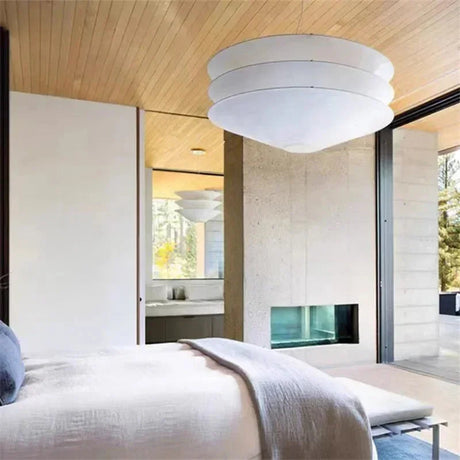 Layered paper shade hung in a pale bedroom