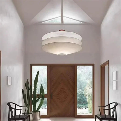 Layered paper shade in a hall with a tall plant