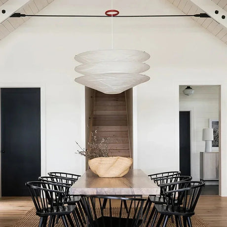 Paper pendant light with a layered white shade above a dining table