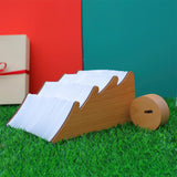 The lamp part way open, the white paper fanning out of the wood cover
