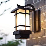 The lantern on a dark brick wall seen at an angle, the frosted glass unlit