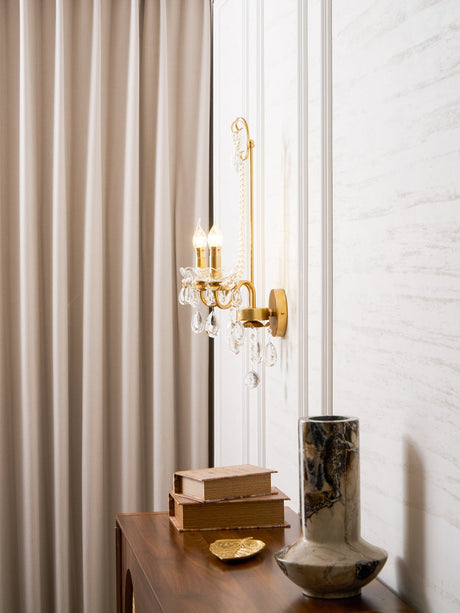 The pearl sconce beside a curtain above a wood console with books and a vase