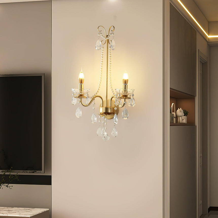 The pearl sconce lit in a hallway beside a doorway and a TV wall