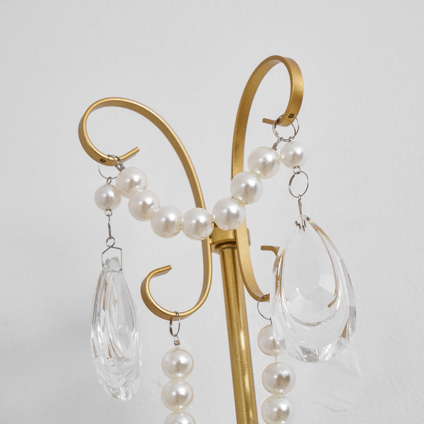 Close view of the scrolled gold top with pearl chains and crystal drops