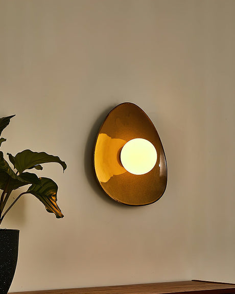 The pebble light glowing amber in the evening beside a plant