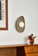 The small pebble light above a wood dresser beside a framed print