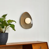 The small pebble light above a sideboard and a plant in a stone pot