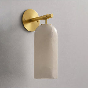 The gold version with its stone cylinder, seen against a plain wall