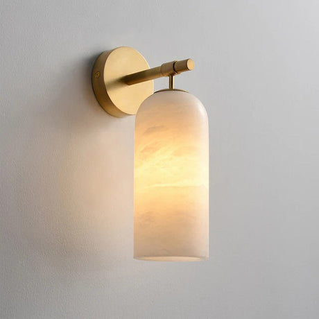 Pillar wall sconce with a lit stone cylinder hanging from a gold disc and arm