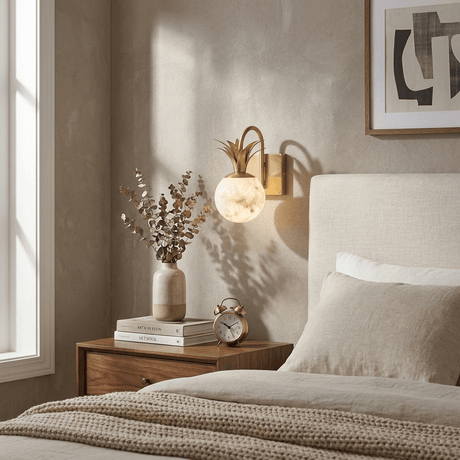 The sconce lit above a nightstand beside a bed with a framed print