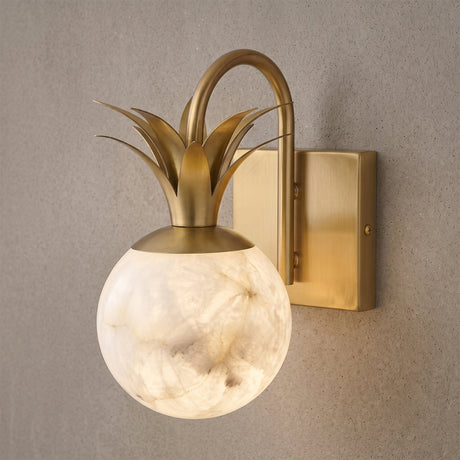 Close view of the gold leaves curling above the lit stone globe