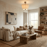 Pleated fabric ceiling light in a living room with pale sofas and an abstract canvas