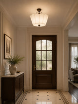 Pleated fabric ceiling light lit in an entry hall with a glazed door and tiled floor