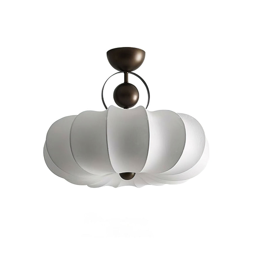 Pleated ceiling light with the white silk shade seen against a plain background