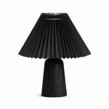 Pleated black shade on a black wood base against a plain white ground