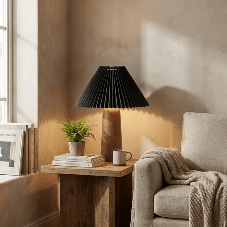 Pleated black shade lamp lit on a side table in a bright living room