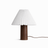 Pleated white shade on a walnut base seen front on against a white ground