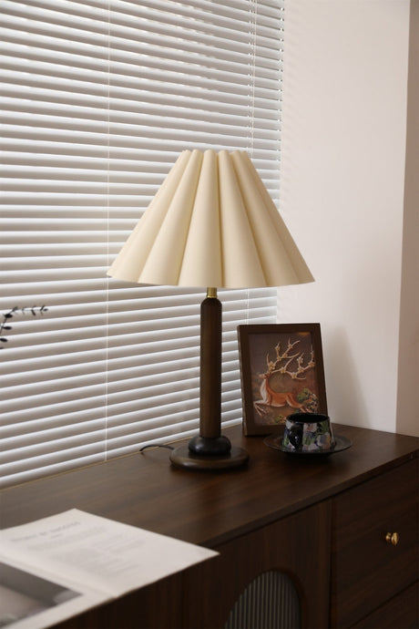 Pleated table lamp unlit and seen from the front on a dresser