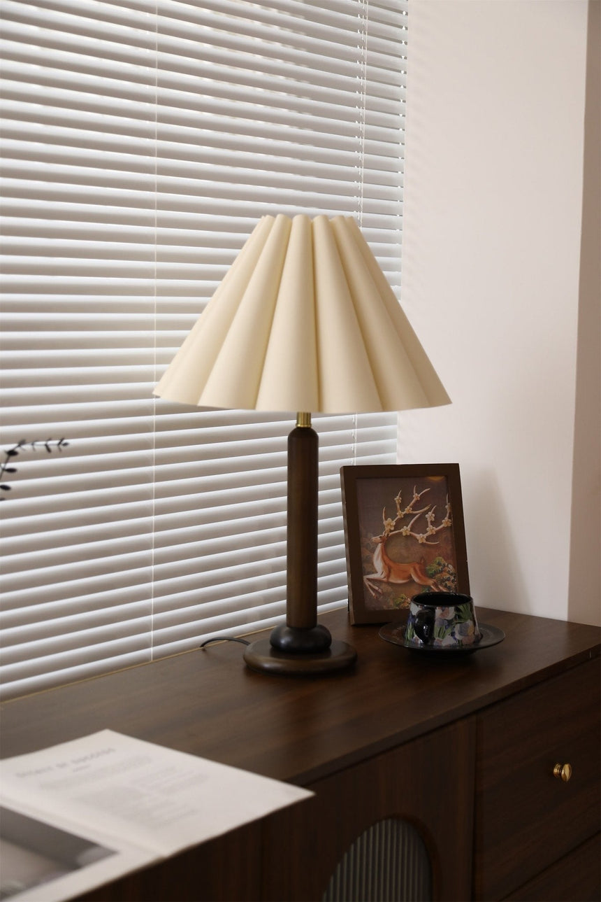 Pleated table lamp unlit and seen from the front on a dresser