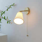 The shade tilted down, its scalloped rim glowing