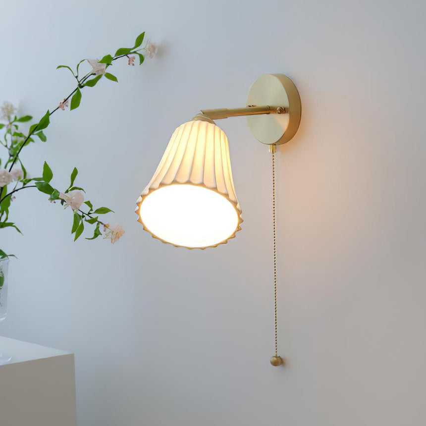 The shade tilted down, its scalloped rim glowing