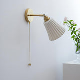The shade unlit on its brass arm, the pleats clear in daylight