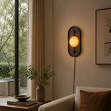 Lamp lit beside a tall window above a stack of books and a curtain