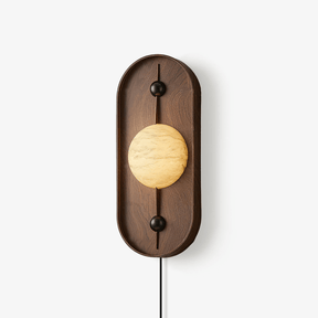 Plug in wall lamp, a stone look disc in a tall walnut frame with a cord