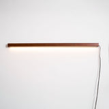 The cord and inline switch running down the wall from the lit bar