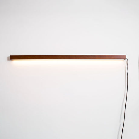 The cord and inline switch running down the wall from the lit bar