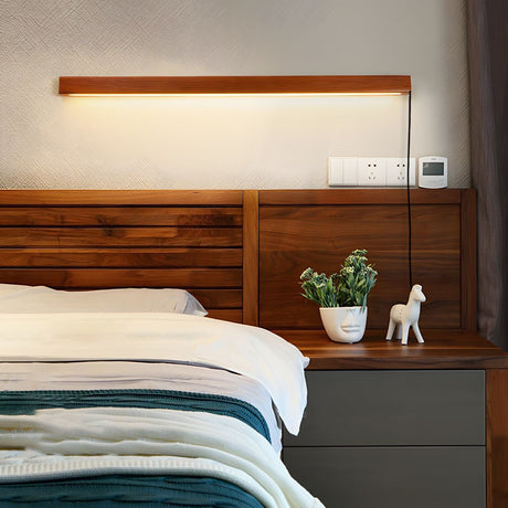 Walnut bar lit above a wood headboard beside a nightstand