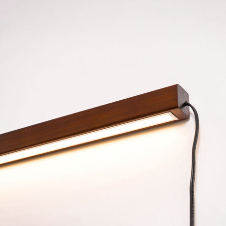 Close view of the walnut bar, the lit strip and the cord at the end