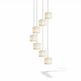 A cascade of unlit alabaster cubes on thin cables at stepped heights