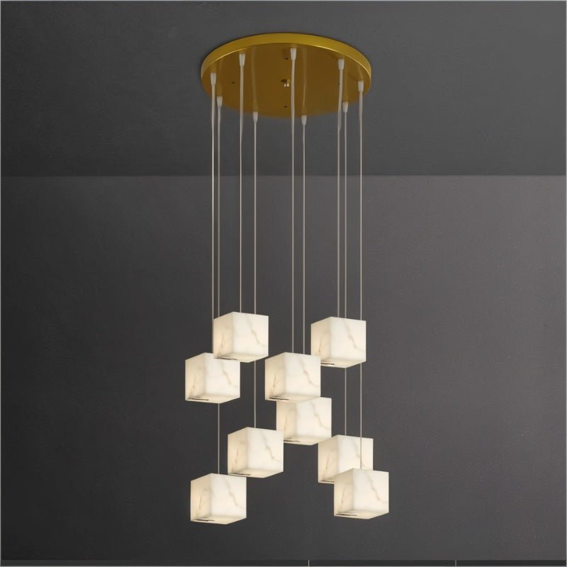 Alabaster cubes hung at staggered heights on cables from a round brass plate