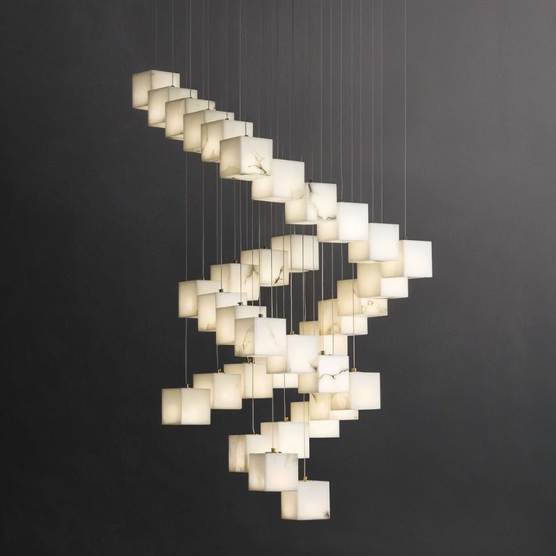 Lit alabaster cubes turning in a spiral as they drop on their cables