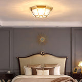 Octagonal brass ceiling light above a bed with a curved headboard