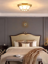 Octagonal brass ceiling light in a bedroom with gray walls