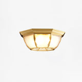 Octagonal brass ceiling light lit and seen from the side